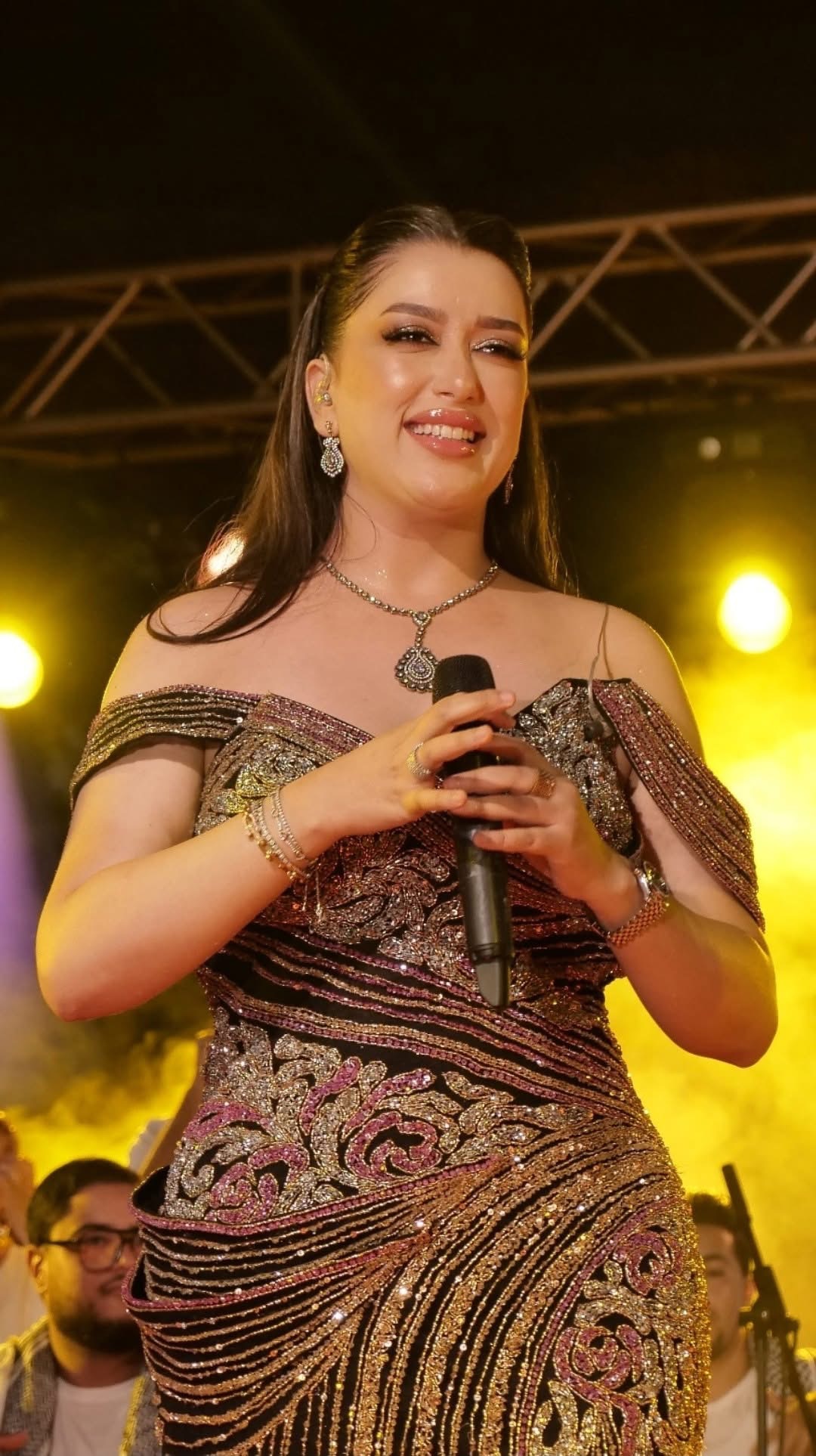 Mariem Noureddine souriante au microphone, sous les lumières de scène