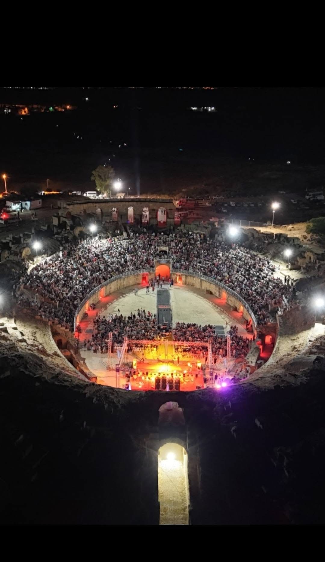 Vue nocturne d’un amphithéâtre accueillant un concert
