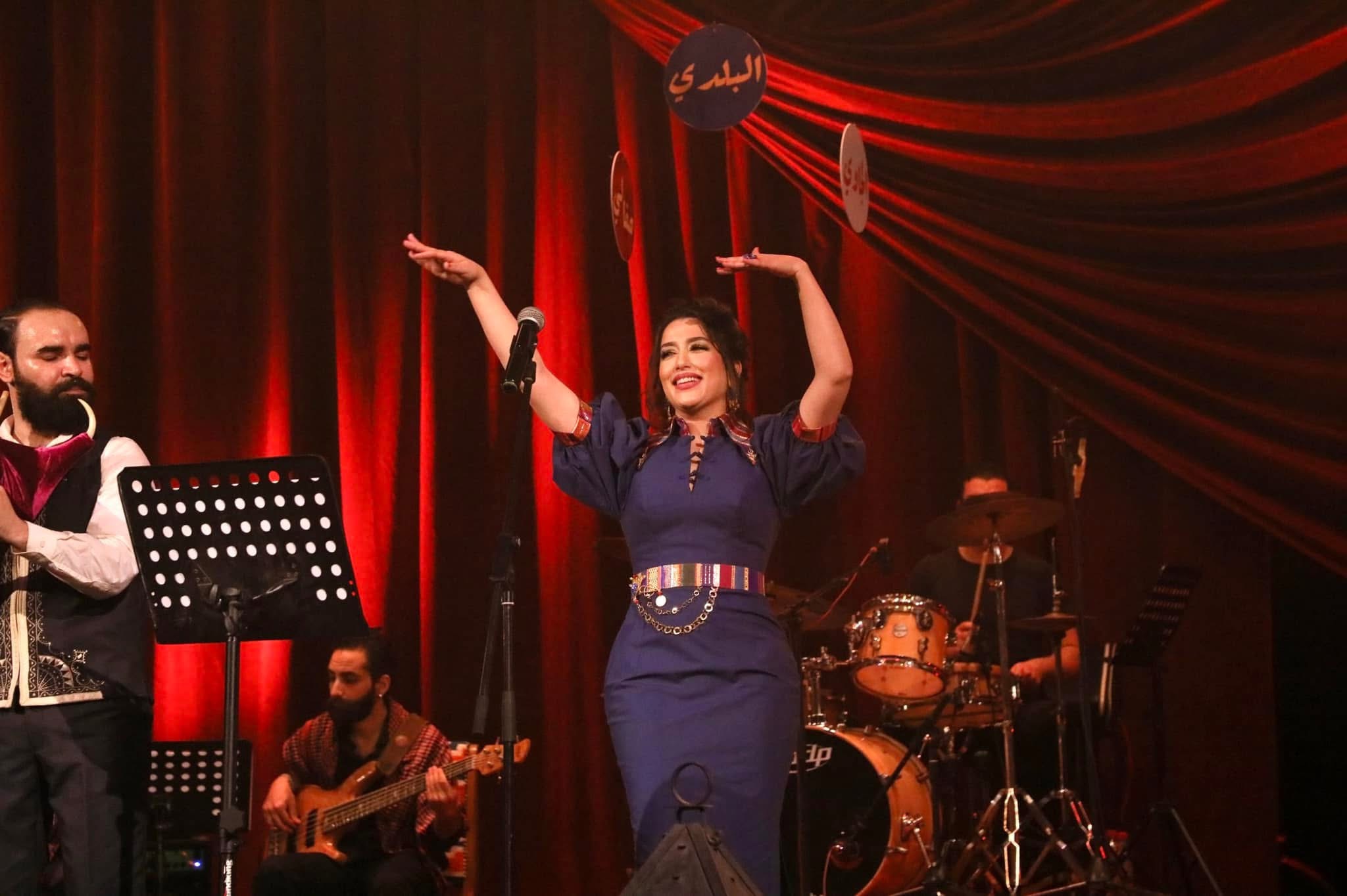 Mariem Noureddine souriante, les bras levés sur scène