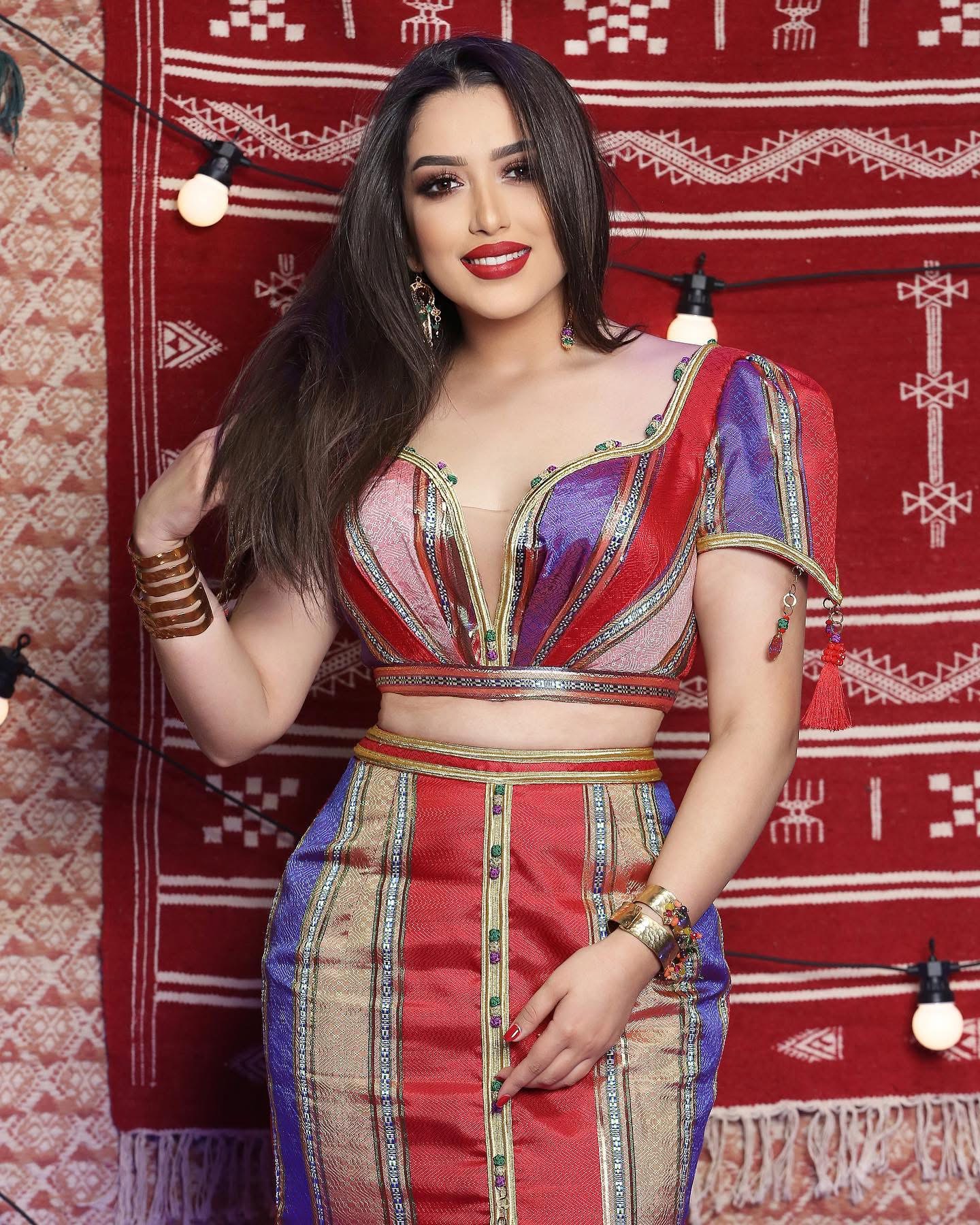 Mariem Noureddine devant un textile traditionnel rouge